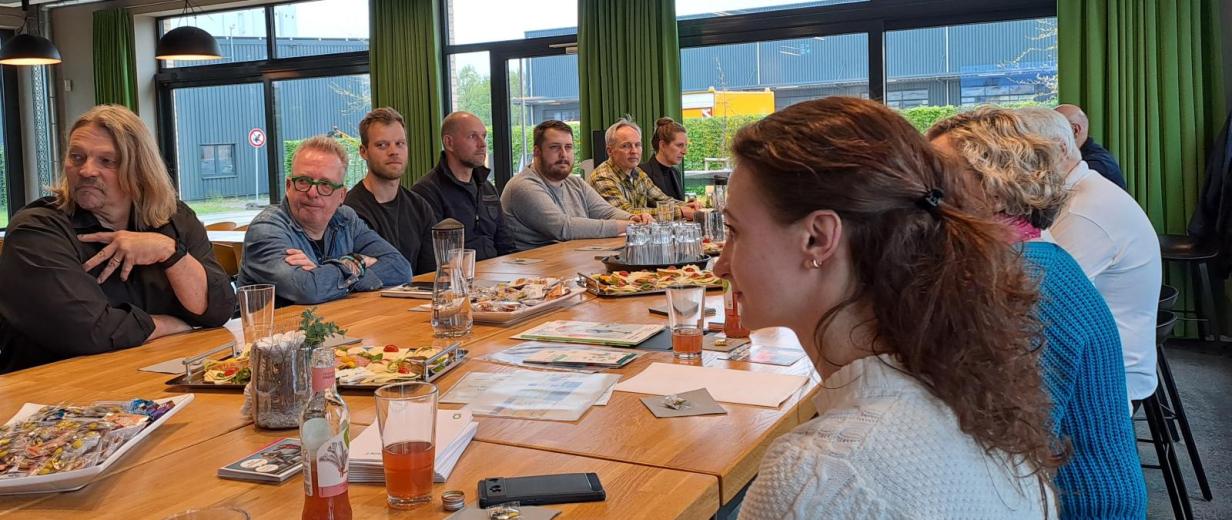 MINT Stammtisch Bramsche Eine Personengruppe sitzt um einen großen Tisch herum.